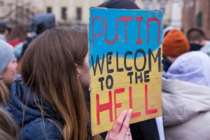 Femme portant une affiche souhait que Poutine aille en enfer