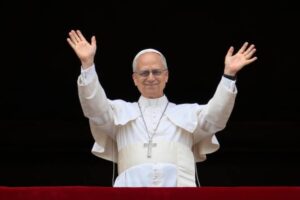 Le pape Léon XIV étendant les bras vers la foule lors de son apparition après le conclave